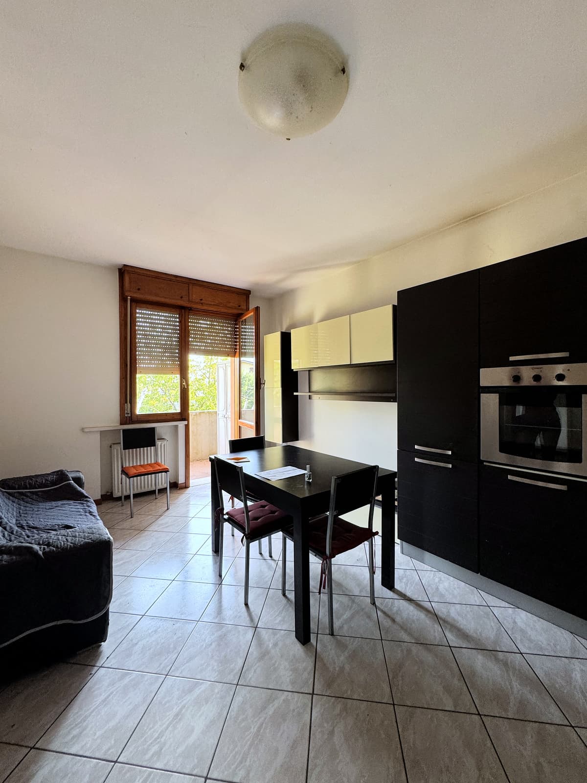 Soggiorno con forno e balcone — Bilocale con balcone e cantina a Quattro Castella