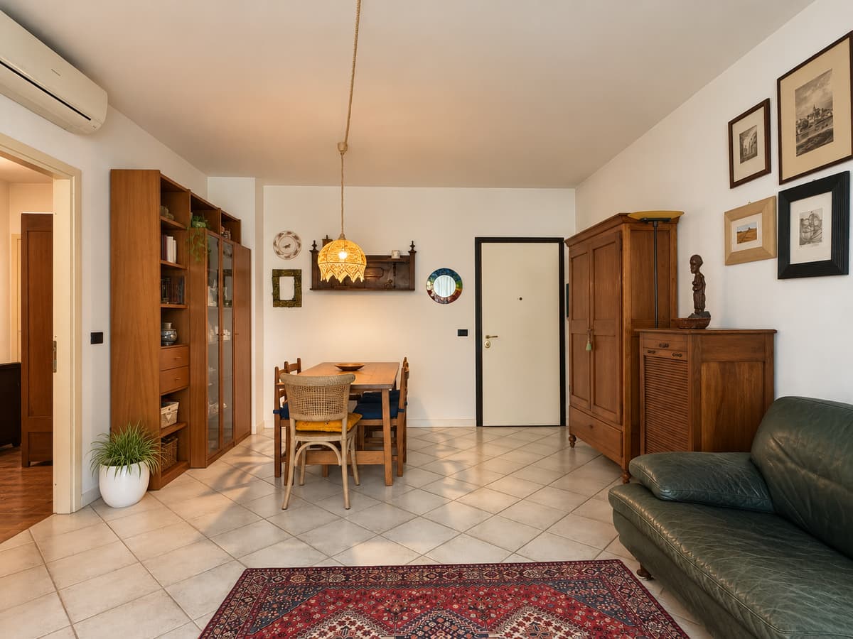 Soggiorno — divano verde, tavolo pranzo, quadri alle pareti — Appartamento di 132 m² con loggia al Buco del Signore