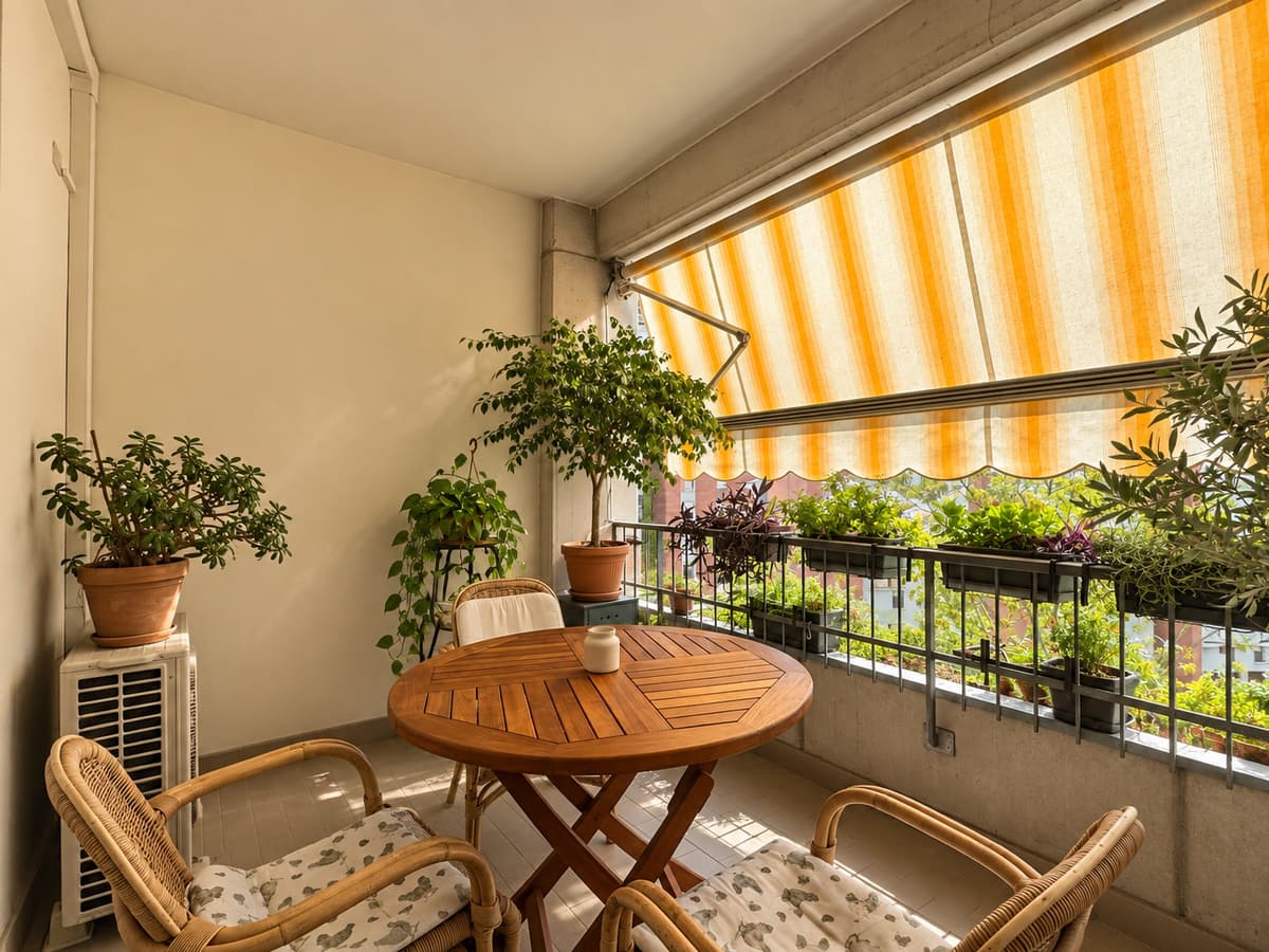 Balcone — tenda arancio, sedie rattan, piante e vista città — Appartamento di 132 m² con loggia al Buco del Signore