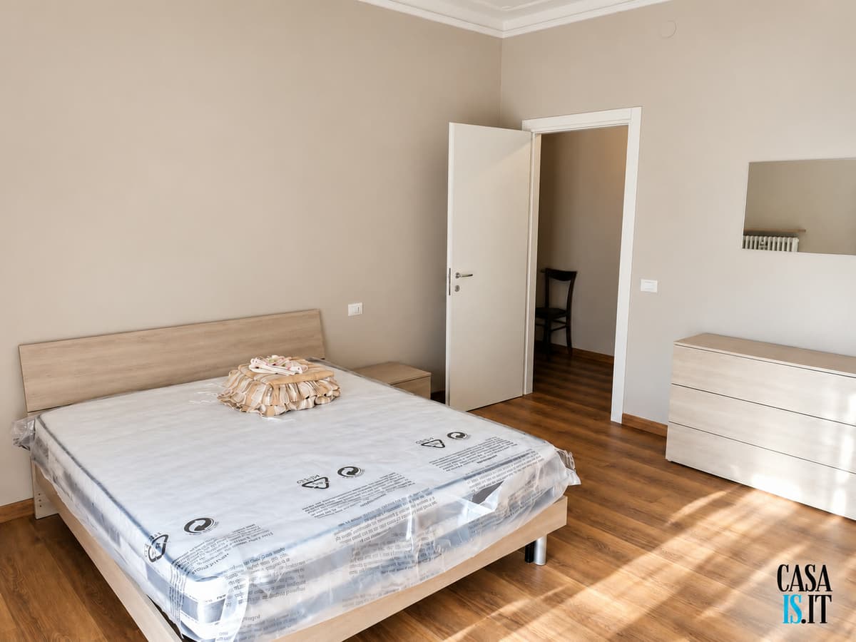 Camera con letto matrimoniale e cassettiera — Quadrilocale di 114 m² al terzo piano in Via Cecati
