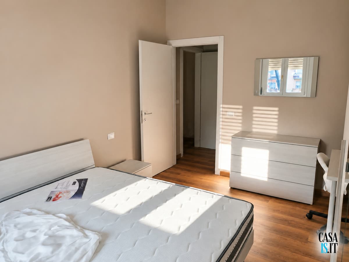 Camera — letto, cassettiera e specchio — Quadrilocale di 114 m² al terzo piano in Via Cecati
