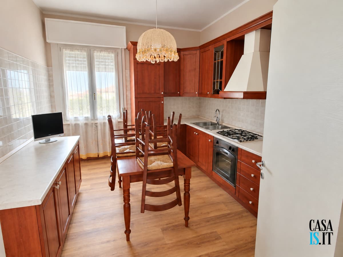 Cucina abitabile con tavolo e sedie, pensili in legno — Quadrilocale di 114 m² al terzo piano in Via Cecati
