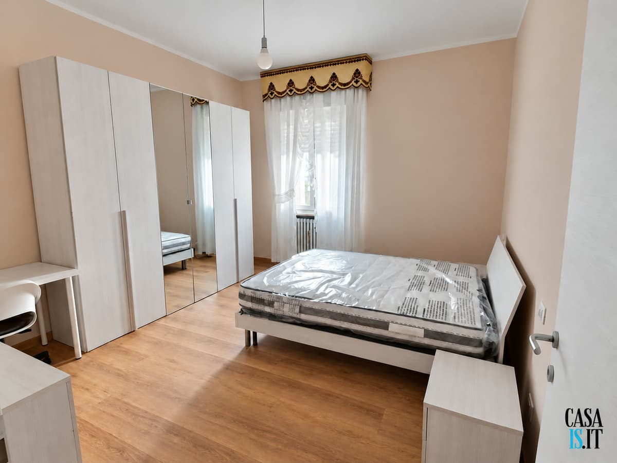 Camera con letto matrimoniale, armadio e scrivania — Quadrilocale di 114 m² al terzo piano in Via Cecati