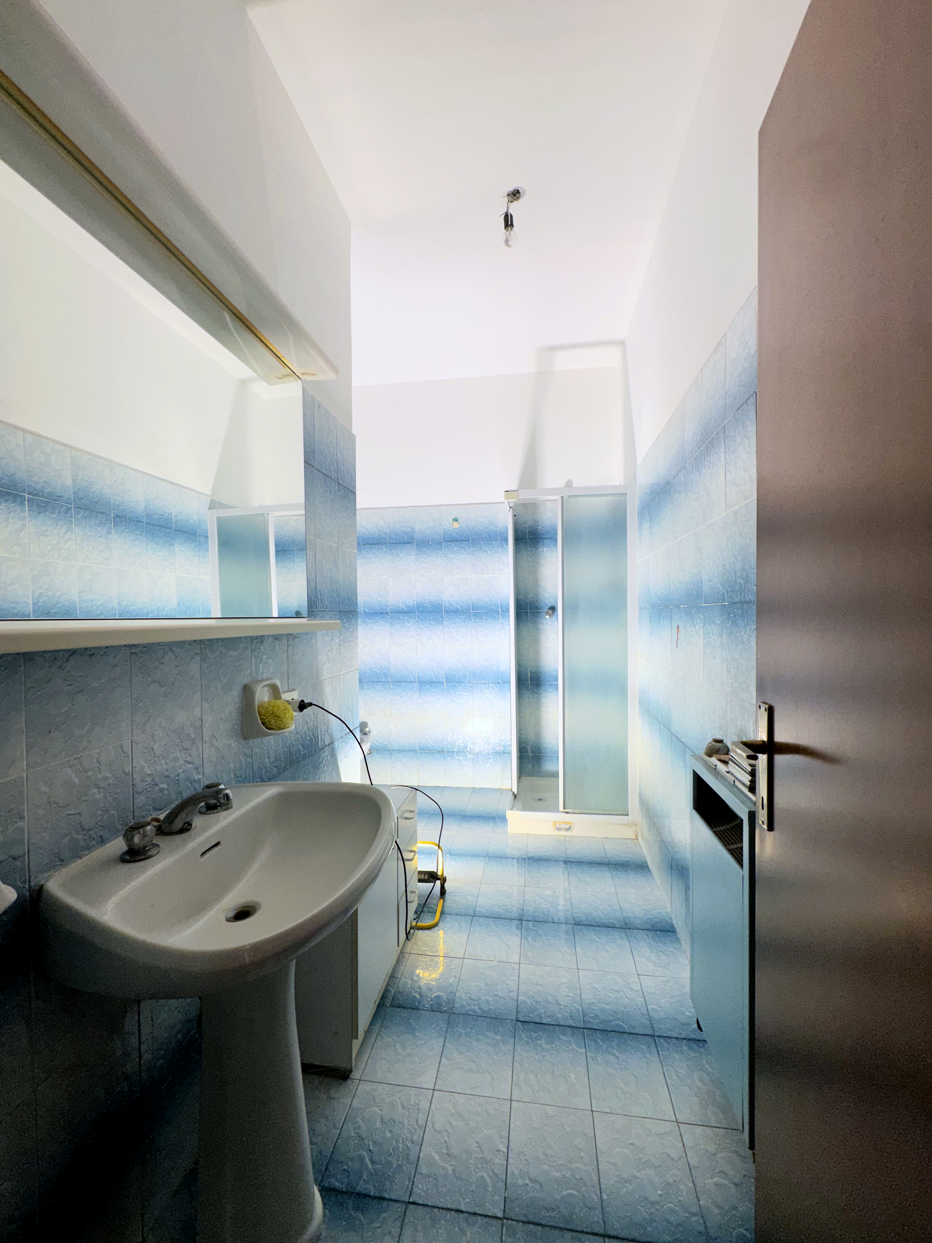 Bagno con piastrelle blu a mosaico