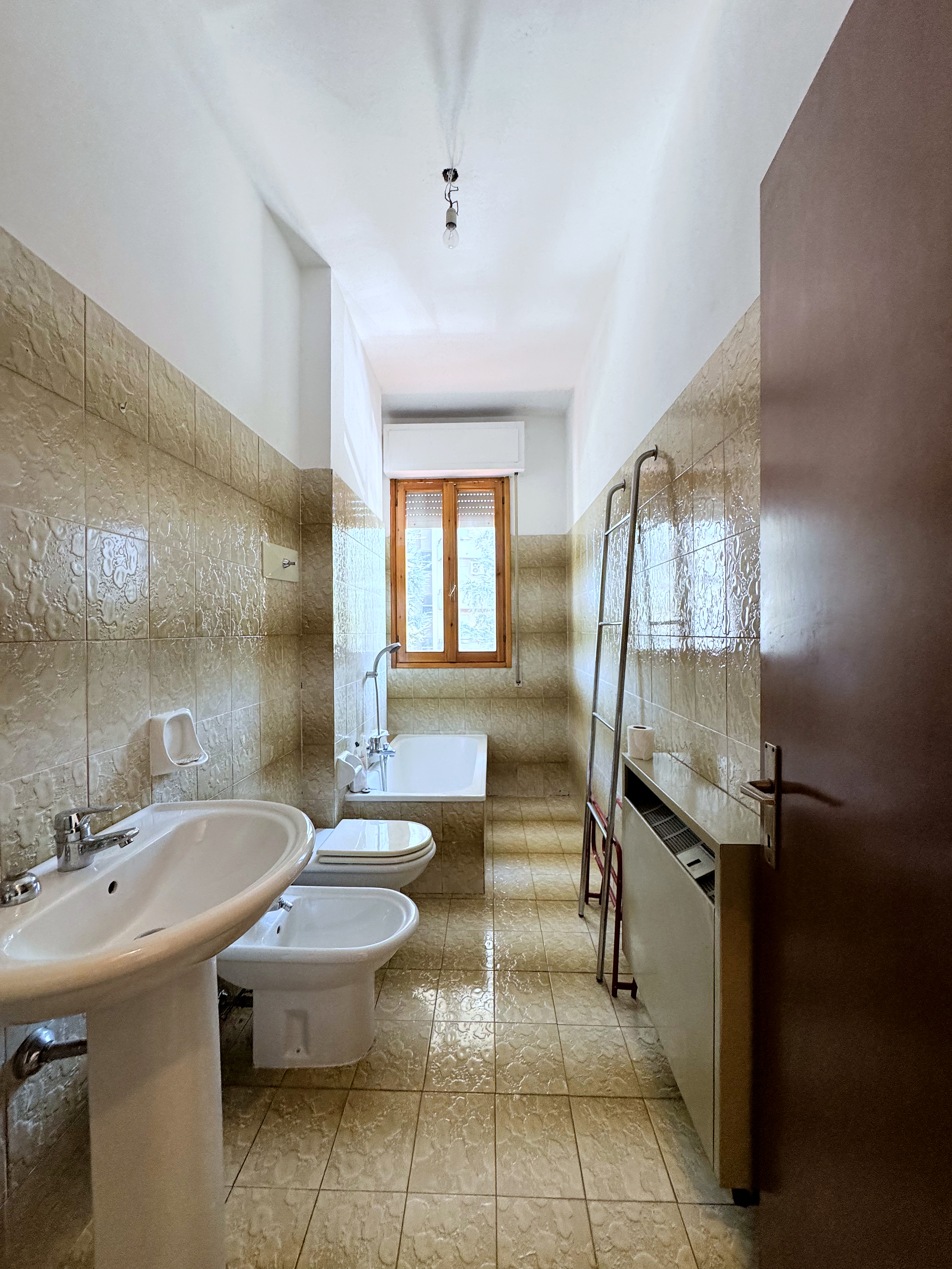Bagno con vasca e piastrelle beige