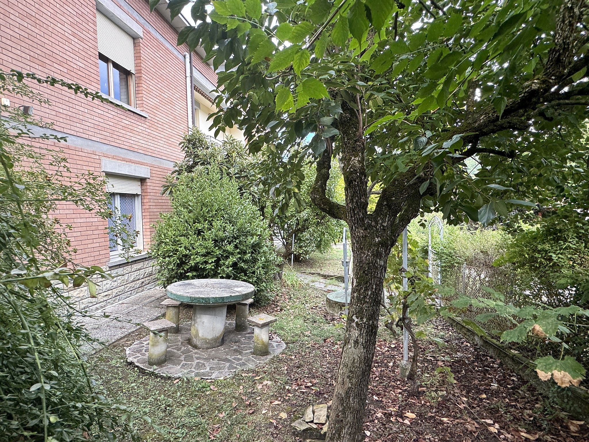 Giardino con tavolo in pietra e villa sullo sfondo