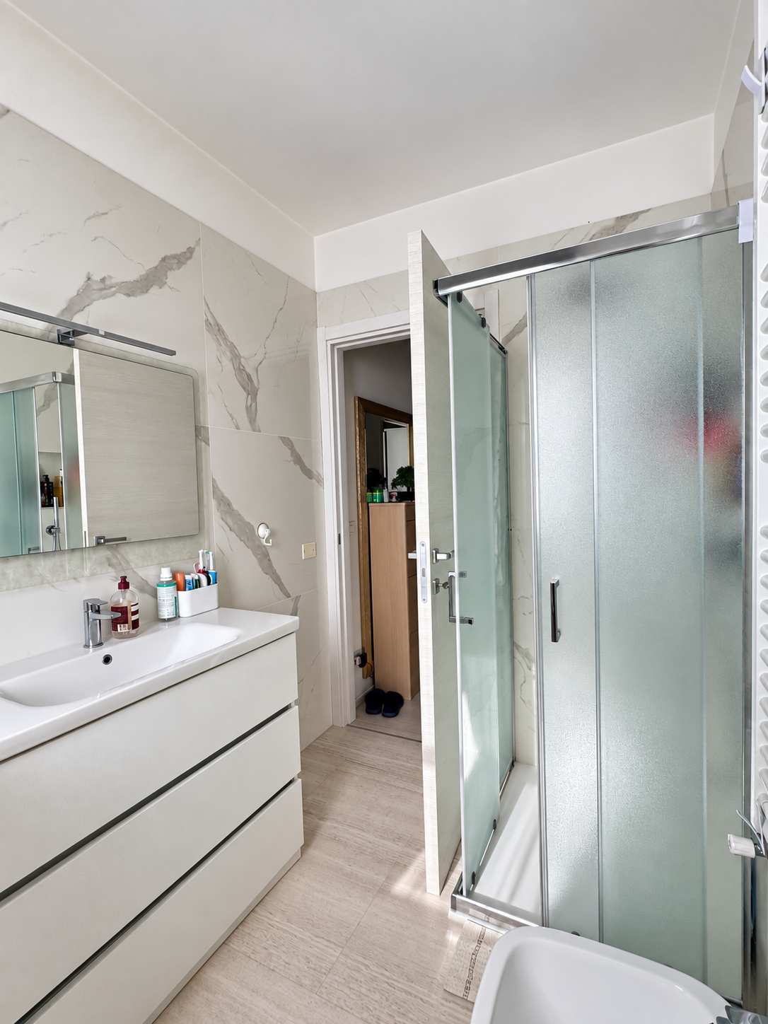 Bagno con doccia e rivestimento marmorizzato