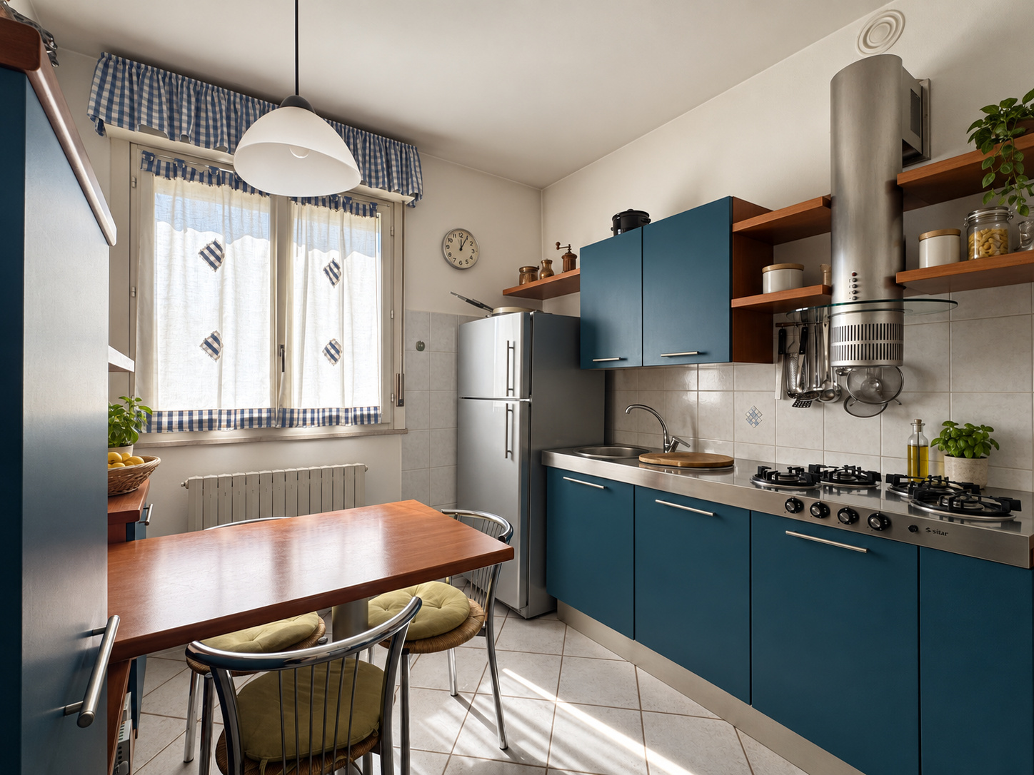 Cucina — mobili blu, tavolo in legno, frigorifero e fornelli