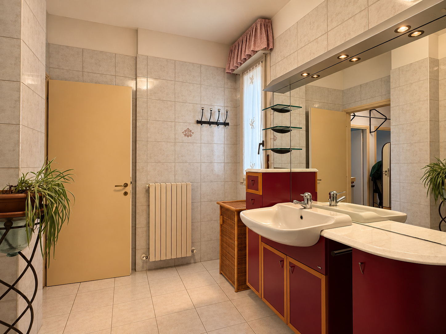 Secondo bagno — doppio lavabo bordeaux, radiatore, mobile rattan